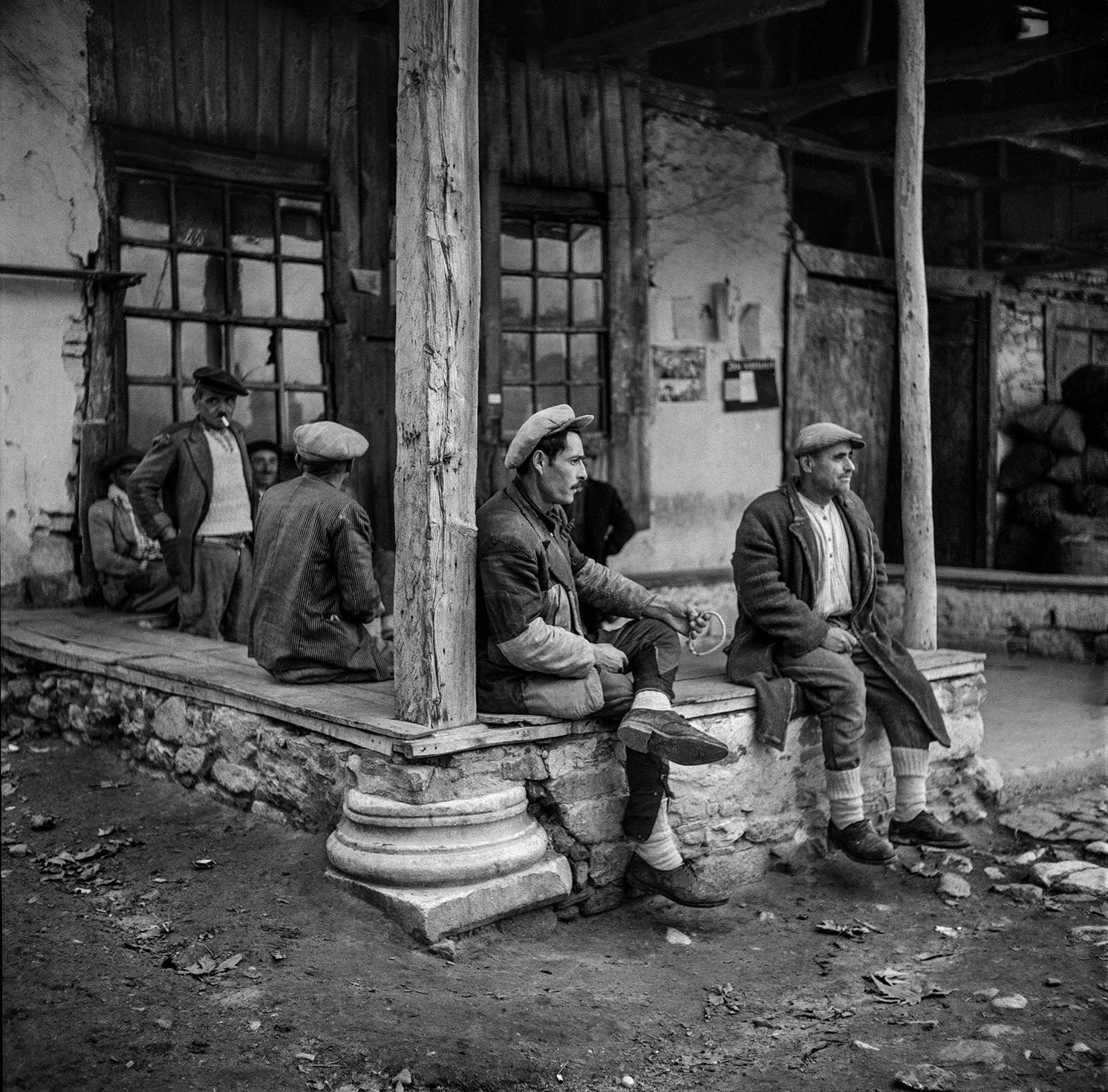Men waiting among the weathered columns and wooden structures of Aphrodisias