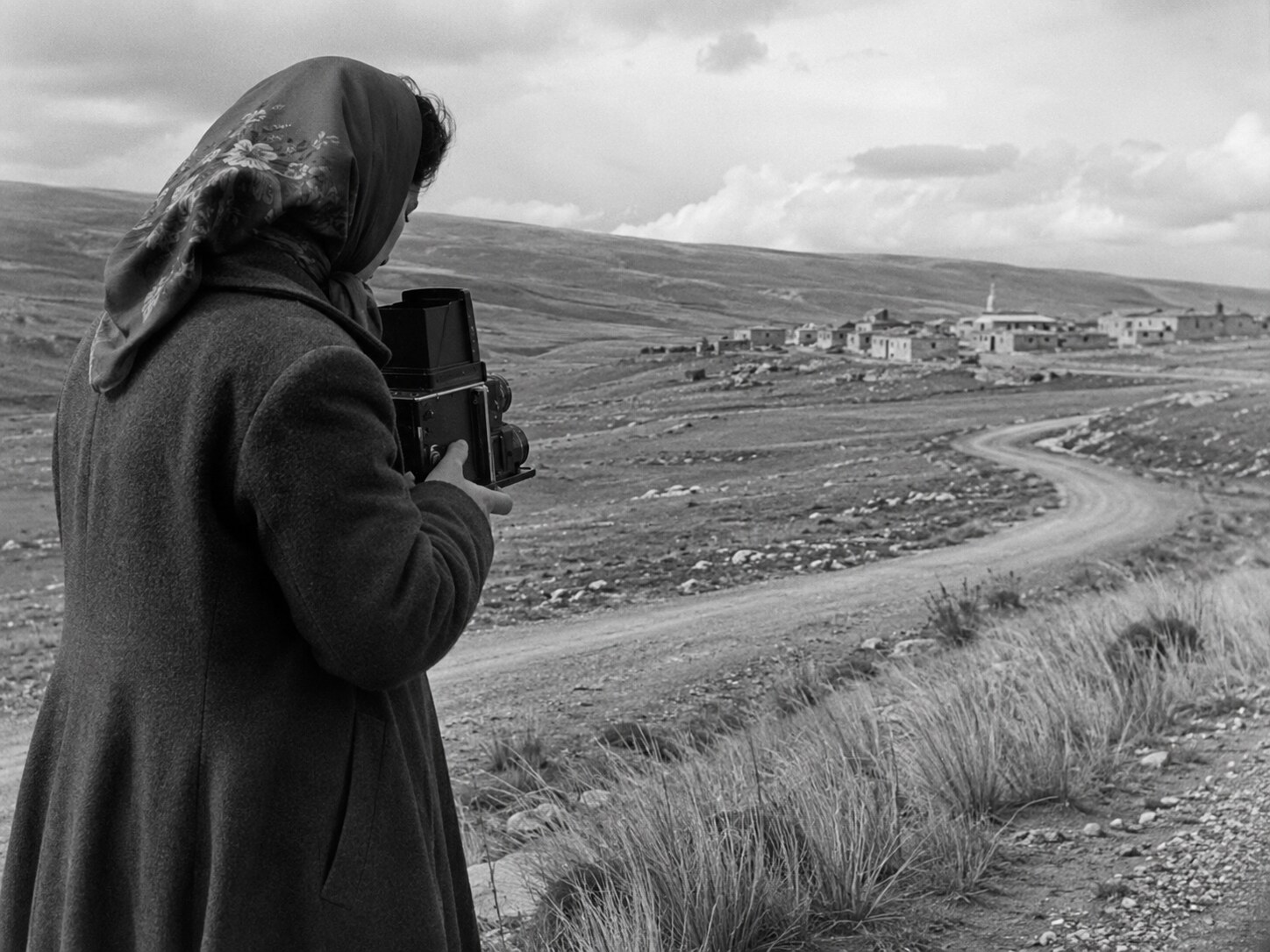 An original black-and-white scene of a woman photographer facing an Anatolian landscape