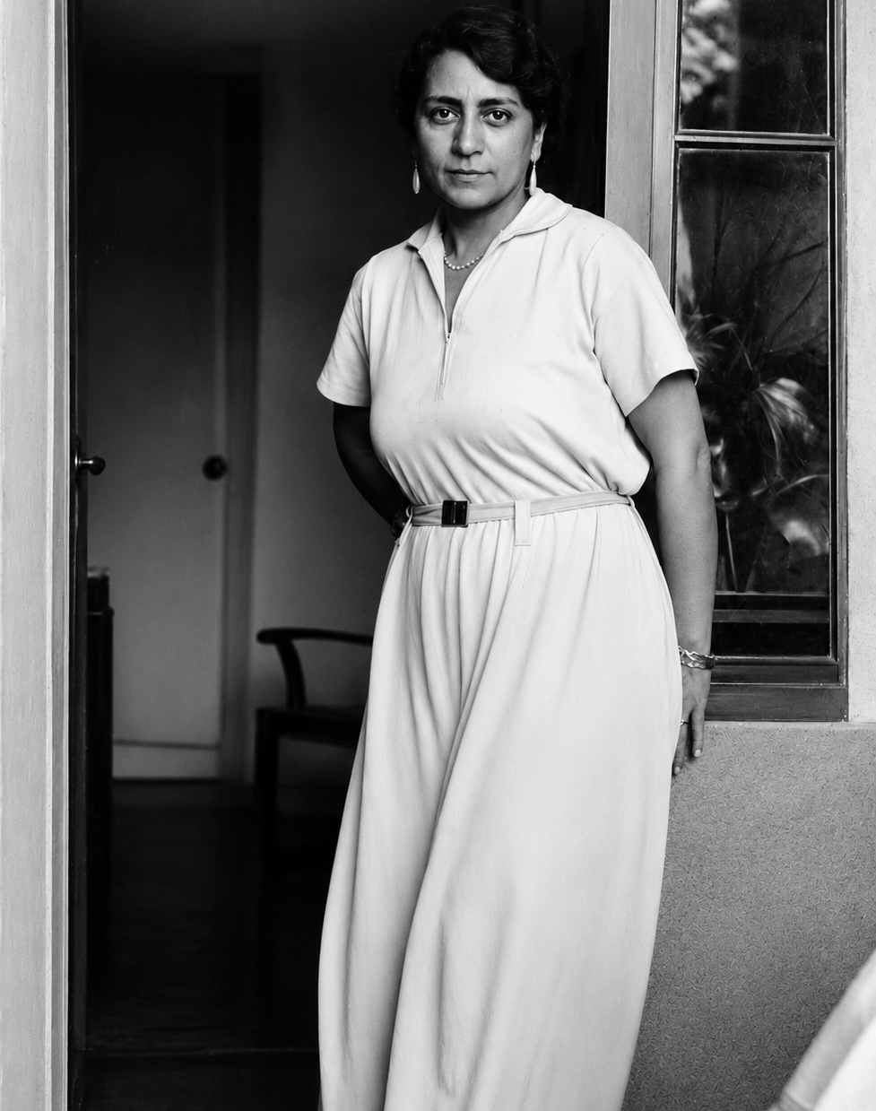 Safiye Ali stands in a doorway in a black-and-white archival portrait